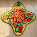 Yellow flower snuffle mat from above on a wood floor with kibble hidden in the petals